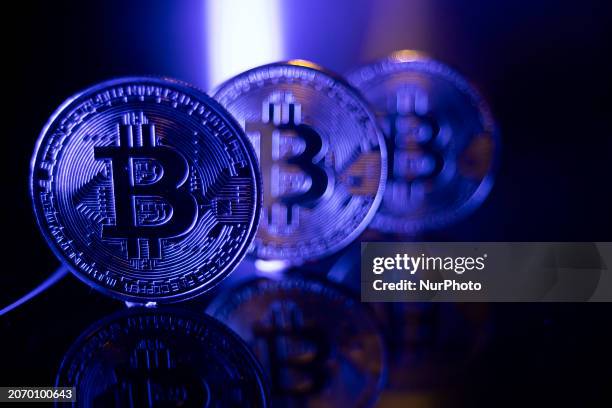 Bitcoins golden physical coin illustration on dark black background with reflection and vibrant color light illumination. Visual representations of...