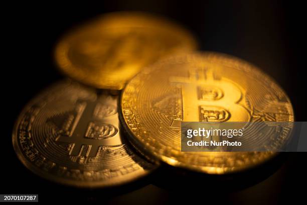 Bitcoins golden physical coin illustration on dark black background with reflection and vibrant color light illumination. Visual representations of...
