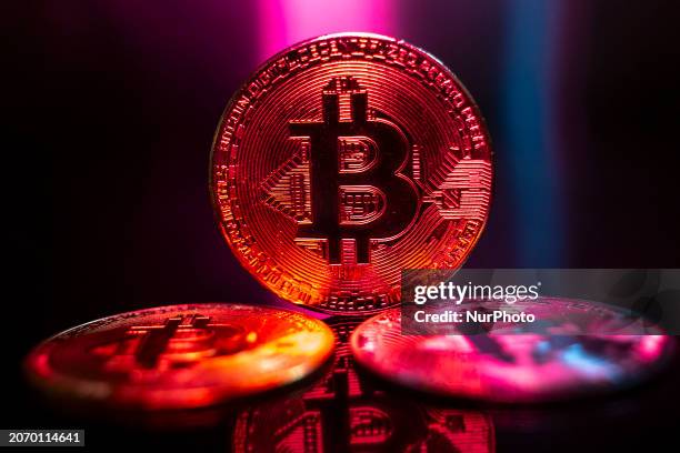 Bitcoins golden physical coin illustration on dark black background with reflection and vibrant color light illumination. Visual representations of...