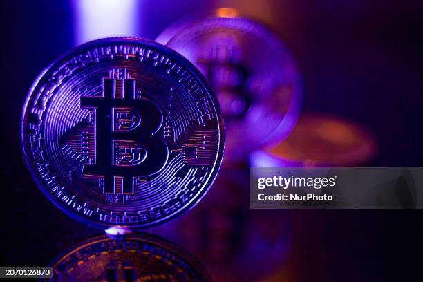 Bitcoins golden physical coin illustration on dark black background with reflection and vibrant color light illumination. Visual representations of...