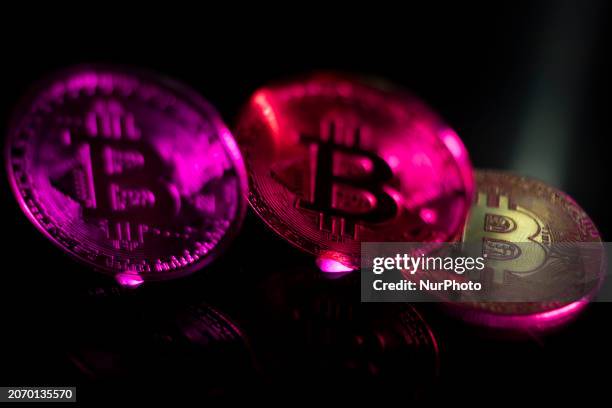 Bitcoins golden physical coin illustration on dark black background with reflection and vibrant color light illumination. Visual representations of...