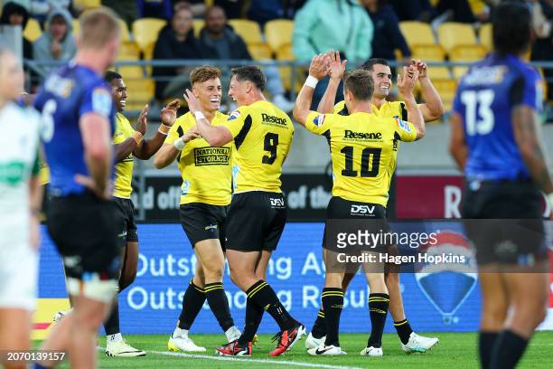 Josh Moorby of the Hurricanes celebrates with teammates after scoring a try during the round three Super Rugby Pacific match between Hurricanes and...