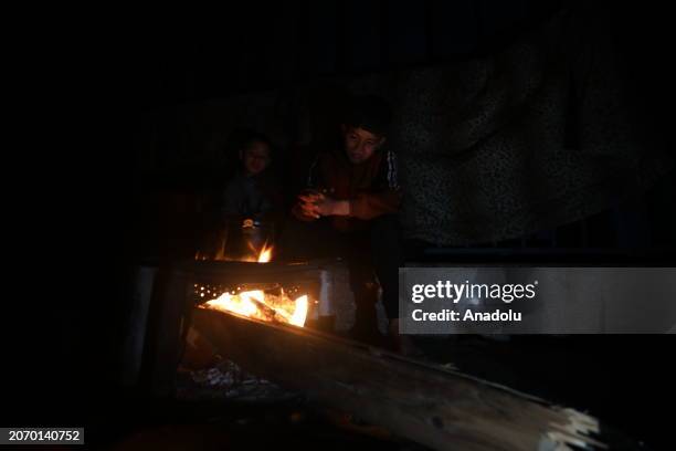 Palestinian family, who left their homes due to the Israeli attacks on the Gaza Strip, has sahur meal with za'atar, pepper sauce, a few pieces of...