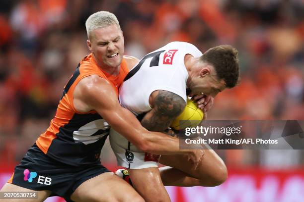 Jamie Elliott of the Magpies is challenged by Harry Himmelberg of the Giants during the AFL Opening Round match between Greater Western Sydney Giants...