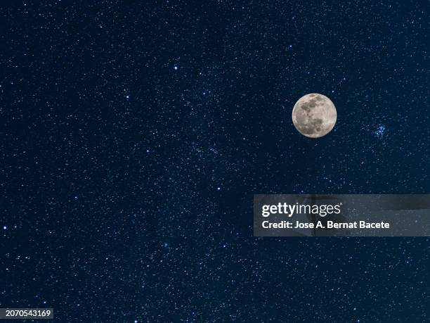 full moon night with a clear sky full of bright stars. - donker stockfoto's en -beelden