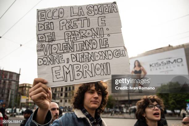 Boy shows a banner which reads: "Ecco la società dei preti e dei padroni: violentano le donne, defendono gli embrioni" during a march for...