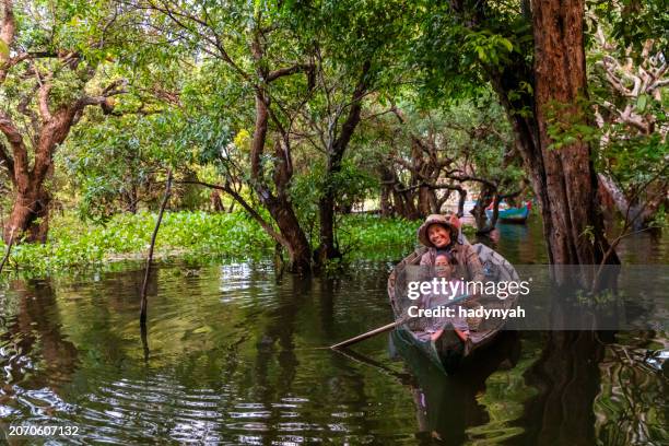 cambodian woman rowing a boat, tonle sap, cambodia - cambodia stock pictures, royalty-free photos & images