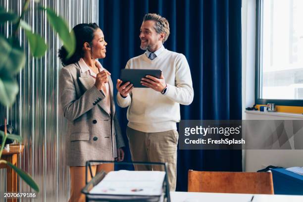 two business colleagues sharing ideas with tablet in modern office - gentleman style stock pictures, royalty-free photos & images