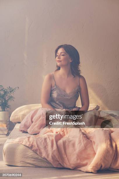 serene woman enjoying a quiet moment in cozy bedroom - cozy bedroom stock pictures, royalty-free photos & images