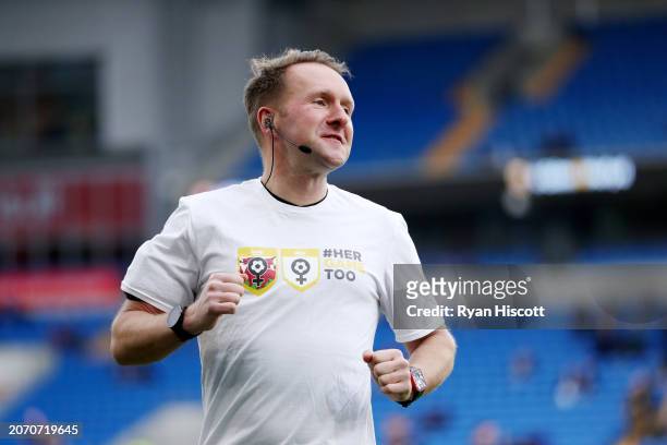 Referee, Oliver Langford can be seen warming up while wearing a "#HerGameToo" t-shirt prior to the Sky Bet Championship match between Cardiff City...