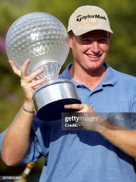 Nedbank Challenge winner Ernie Els of South Africa holds the trophy after beating Scotland's Colin Montgomery by eight strokes with a score of 63, on...