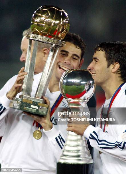 Spanish club team Real Madrid captain Fernando Ruiz Hierro holding the Inter-Continental Cup shares a smile with his teammate Raul Gonzalez who...