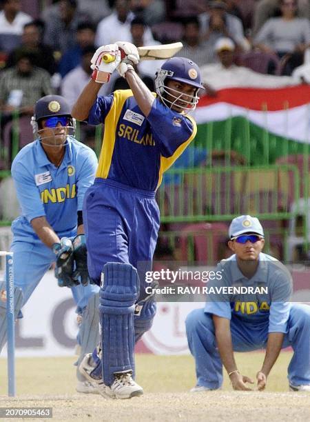 Sri Lankan batsman Kunar Sangakkara hits a ball to boundary as Indian wicketkeeper Rahul Dravid and captain Sourav Ganguly look on during the ICC...
