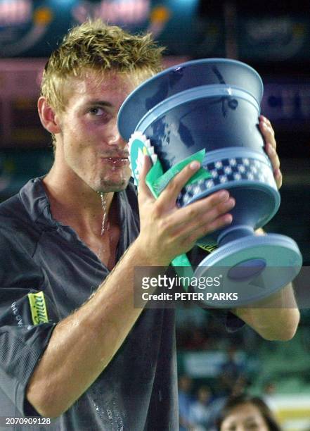 Juan Carlos Ferrero of Spain drinks Champagne from his trophy after beating compatriot Carlos Moya in the final of the Salem Open Tennis Tournament...