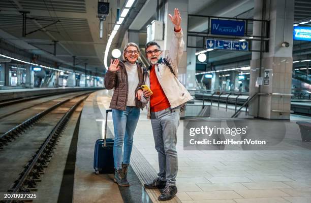 mature couple waiting for their subway - senior couple smiling stock pictures, royalty-free photos & images