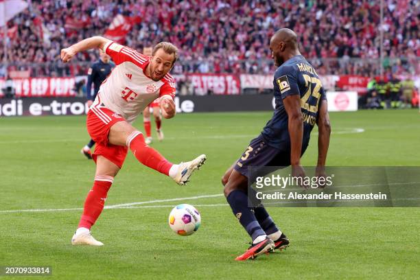 Harry Kane of Bayern Munich shoots whilst under pressure from Josuha Guilavogui of 1.FSV Mainz 05 during the Bundesliga match between FC Bayern...