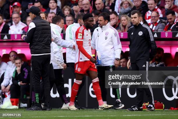 Alphonso Davies of Bayern Munich looks dejected as he leaves the pitch after sustaining an injury during the Bundesliga match between FC Bayern...