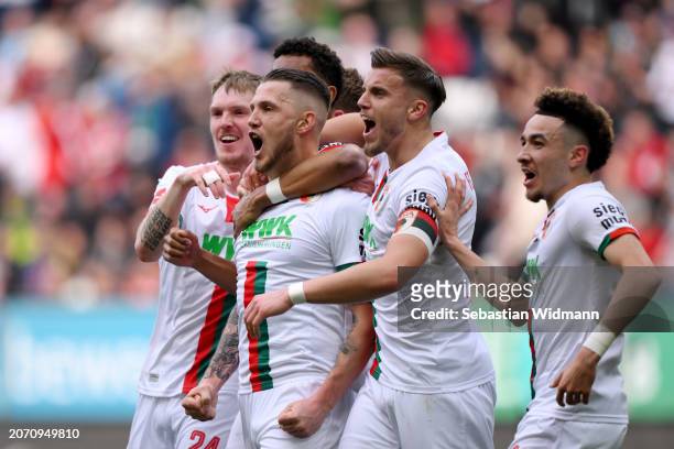 Jeffrey Gouweleeuw of FC Augsburg celebrates scoring his team's first goal with teammates during the Bundesliga match between FC Augsburg and 1. FC...