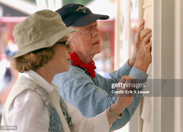 Former U.S. President Jimmy Carter and his wife Rosalyn attach siding to the front of a Habitat for Humanity home being built June 10, 2003 in...