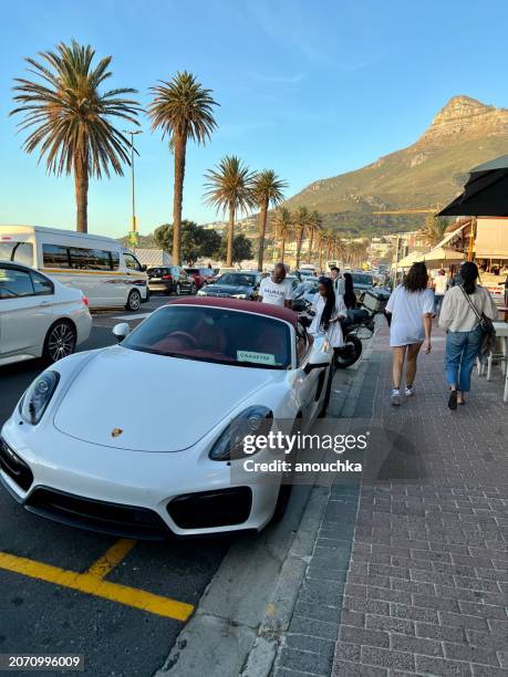 cars parked along the road in camps bay, cape town, south africa - camps bay stock pictures, royalty-free photos & images