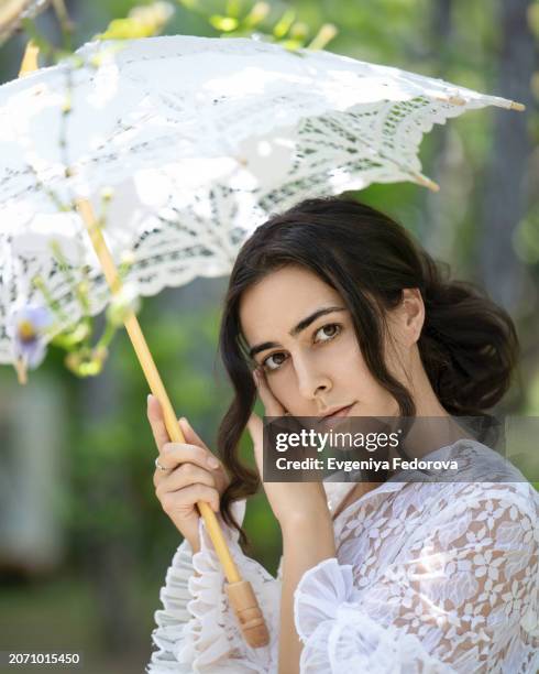 close-up portrait of a girl under a lace umbrella in the garden - bali women tradition head stock pictures, royalty-free photos & images