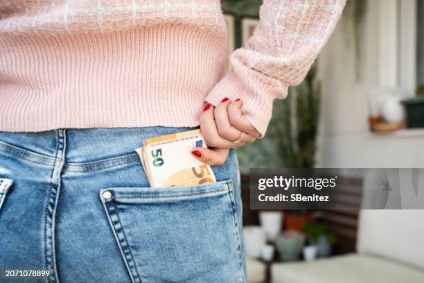 a woman is holding a fifty euro bill in her pocket - one hundred euro note stock pictures, royalty-free photos & images