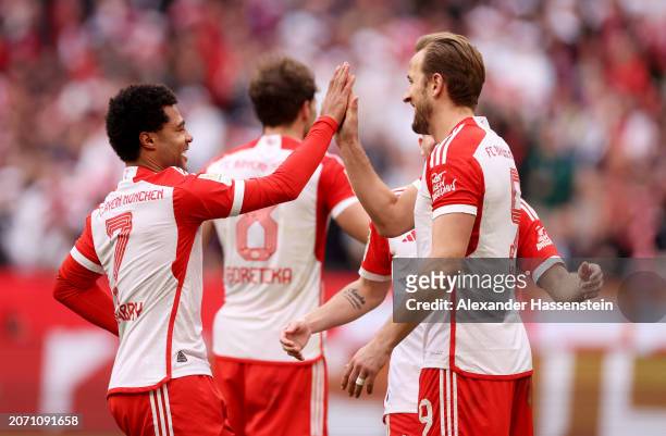 Harry Kane of Bayern Munich celebrates scoring his team's seventh goal and his hat-trick goal with teammate Serge Gnabry during the Bundesliga match...