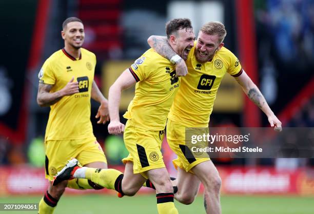 Jack Robinson of Sheffield United celebrates scoring his team's second goal with teammate Oliver McBurnie during the Premier League match between AFC...