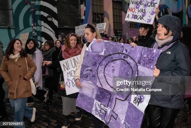 Participants march while holding a banner painted with the female symbol on March 9, 2024 in Dublin, Ireland. Today's march is organised by the Rosa...