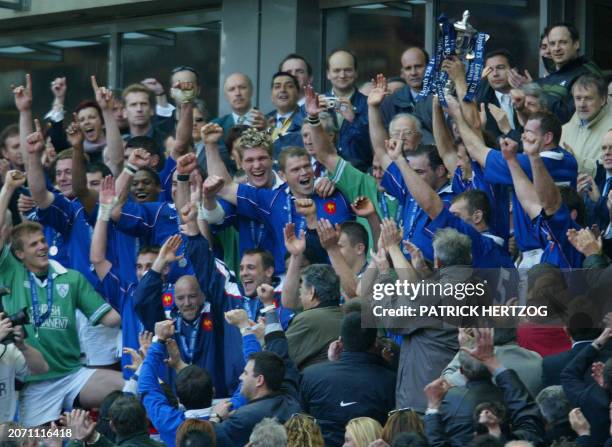 French prop Pieter De Villiers celebrates surrounded by the French team after receiving the Six Nations rugby tournament trophy after defeating...