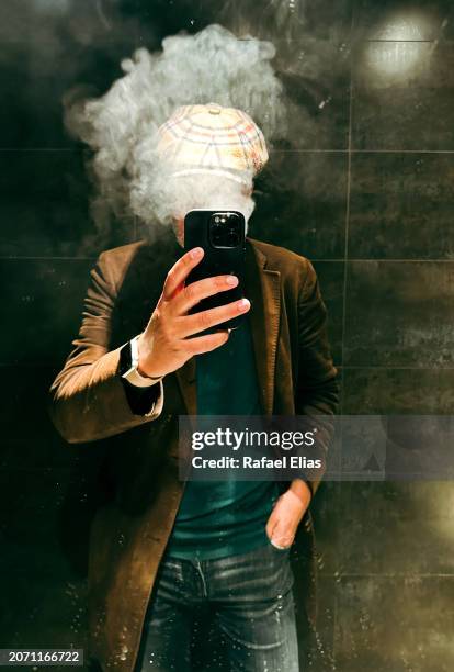 man taking selfie while exhaling smoke - burn out smoke stock pictures, royalty-free photos & images