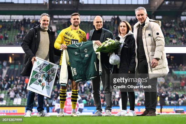 Niclas Fuellkrug of Borussia Dortmund receives a number of gifts from SV Werder Bremen staff during the Bundesliga match between SV Werder Bremen and...