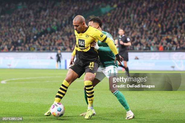 Donyell Malen of Borussia Dortmund and Felix Agu of SV Werder Bremen battle for the ball during the Bundesliga match between SV Werder Bremen and...