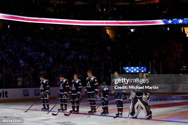 Members of the Colorado Avalanche stand during the playing of the American national anthem prior to the game against the Minnesota Wild at Ball Arena...