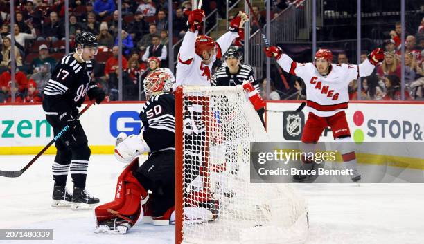 Evgeny Kuznetsov and Jesper Fast of the Carolina Hurricanes celebrate a third period goal by Jesperi Kotkaniemi against Nico Daws of the New Jersey...