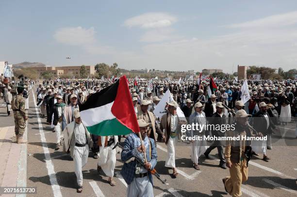 Yemen's Houthi followers from state servants carry weapons as they take part in a rally and parade held against the U.S.-led aerial attacks on Yemen...