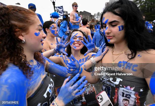 Duke University students paint themselves blue as they prepare for the game between the Duke Blue Devils and the North Carolina Tar Heels at Cameron...