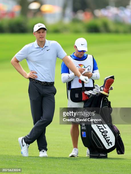 Cam Davis of Australia prepares to play his second shot on the first hole with his caddie Andrew Tschudin during the third round of the Arnold Palmer...