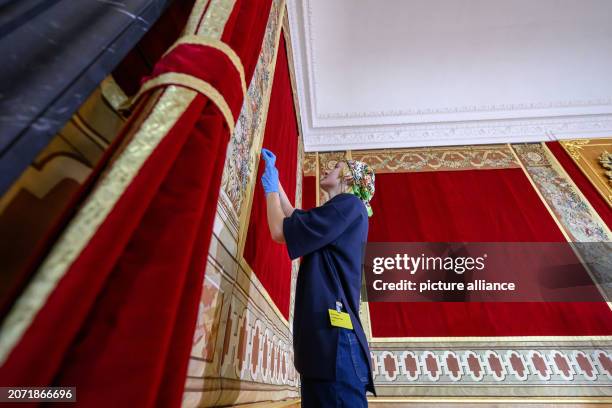 March 2024, Saxony, Dresden: Sirke Farwick, a textile restorer from Vienna, is working on hanging the last tapestries in the Royal Parade Rooms in...