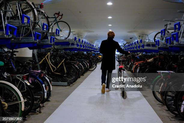 People arrive at underwater parking garage to park / take their bicycles in Amsterdam, Netherlands on February 24, 2024. Bicycles, which are a way of...