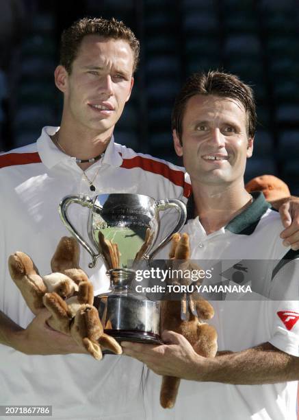 Fabrice Santoro of France and partner Michael Llodra pose with the winners' trophy following their victory in the men's doubles final at the...