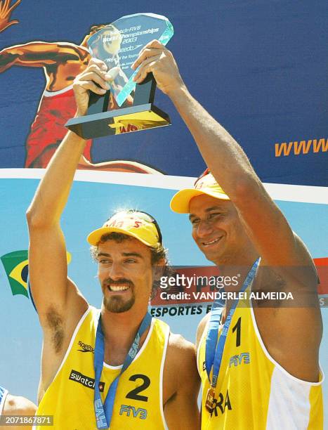 Brazilian beach volleyball team players Emanuel Rego and Ricardo Santos celebrate on the podium after defeating by 2-0 the US Holdren/Metzger team at...