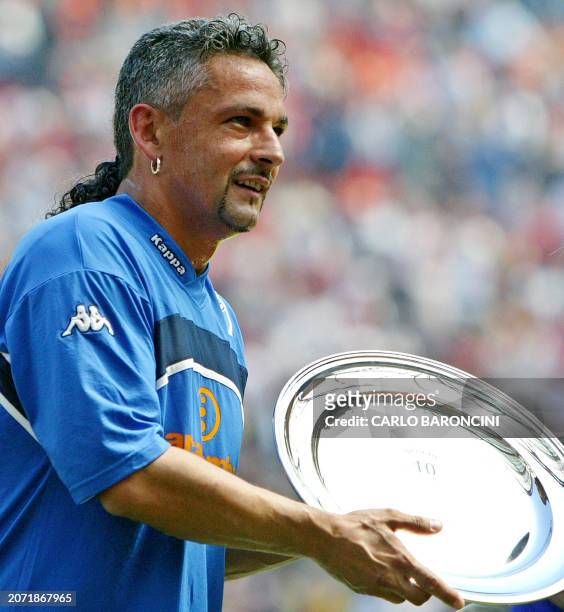 Brescia's captain Roberto Baggio holds a trophy received for his career prior their Italian Serie A football match against AC Milan at San Siro...