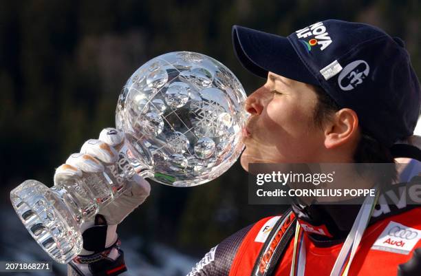 Overall winner of the women's World Cup Downhill competition, Austria's Michaela Dorfmeister, kisses her trophy 12 March 2003, after the final race...