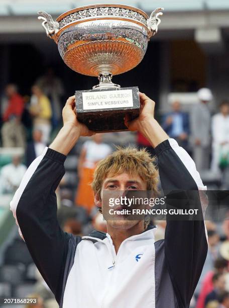 Spain's Juan Carlos Ferrero displays his trophy, 08 June 2003 in Paris, following his Roland Garros French Tennis Open final match against...