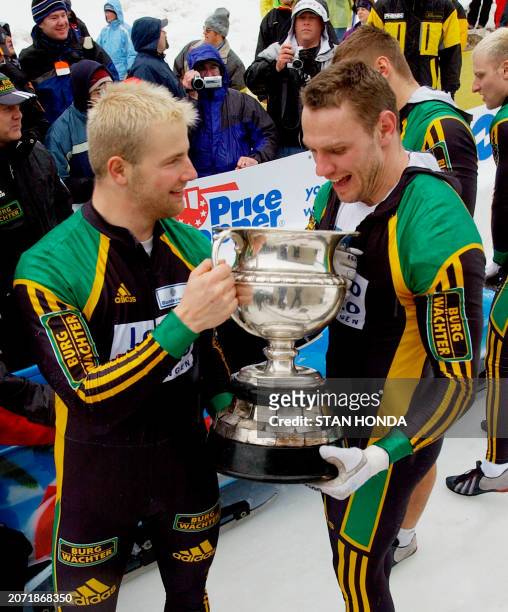 Driver Andre Lange and Carsten Embach of the Germany-1 bobsleigh team celebrate with the Martineau Trophy after winning the 4-man 2003 Verizon FIBT...