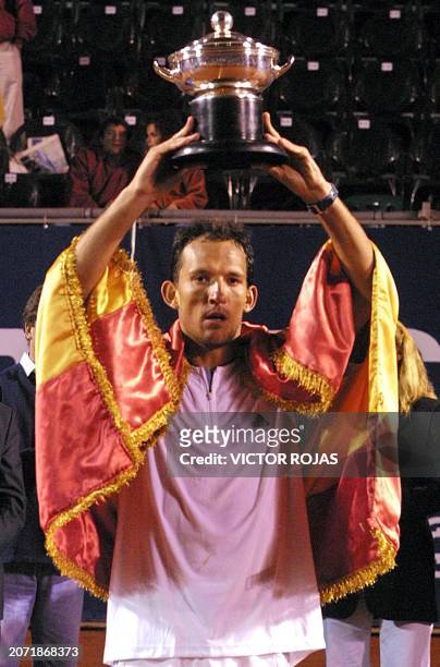 Spain's David Sanchez lifts his winning trophy after defeating Mercelo Rios during the tennis match in Vina del Mar, Chile 16 February 2003. El...