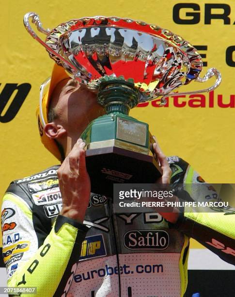 French Randy de Puniet kisses his trophy after winning the Grand Prix of Catalunya in the 250 cc category in Montmelo near Barcelona, 15 June 2003....