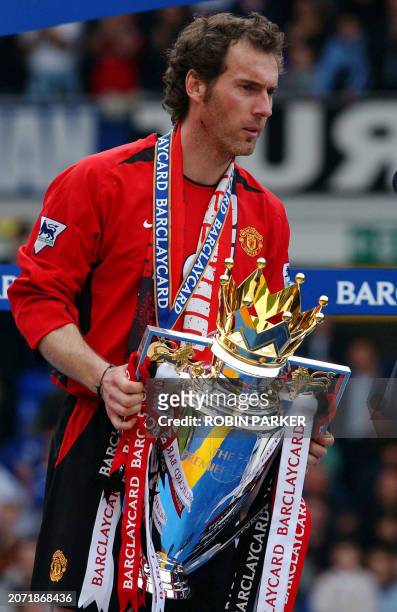 Manchester United's French defender Laurent Blanc holds the Premier league trophy after defeating Everton at Goodison park in Liverpool 11 May 2003....