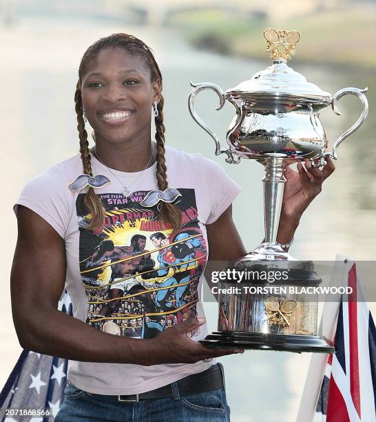 Serena Williams of the US poses beside the Yarra River with the winner's trophy following her victory in their women's singles final at the...